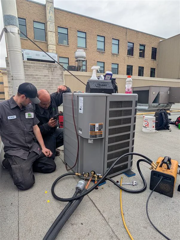 Two Welldone technicians diagnosing commercial rooftop HVAC equipment